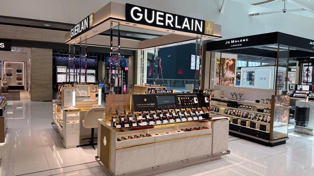 Gondola island display with brass and marble counters, installed in Bahrain retail