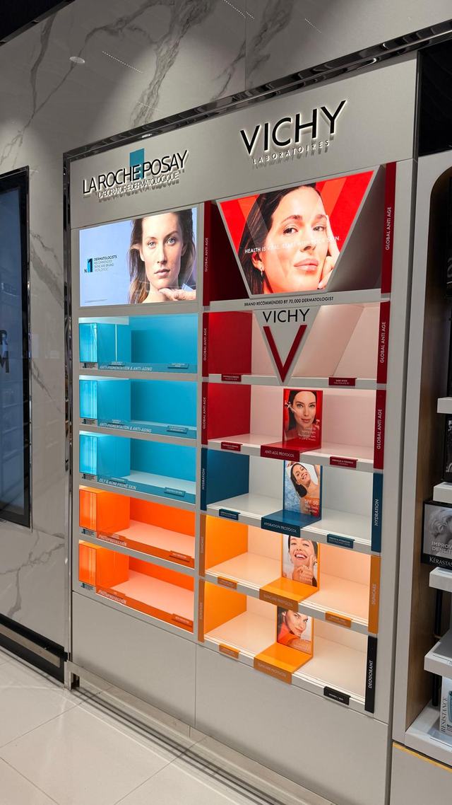 Colour-blocked retail product wall with backlit shelving, installed in Bahrain