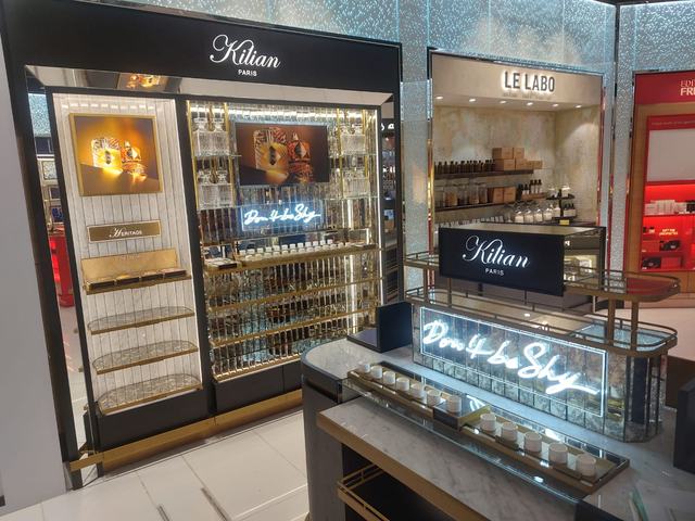 Lit retail wall unit with brass detailing and illuminated counter, installed in Bahrain